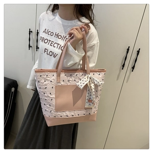 Detail of pink floral embossed tote bag with bow decoration and geometric silk scarf