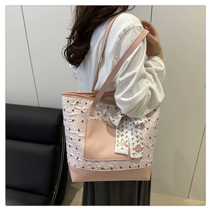 Shoulder bag with pink pleats, bow patterns, and a decorative silk scarf detail