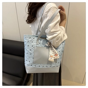 Vue latérale d'un grand sac cabas matelassé bleu clair avec foulard sur un mannequin