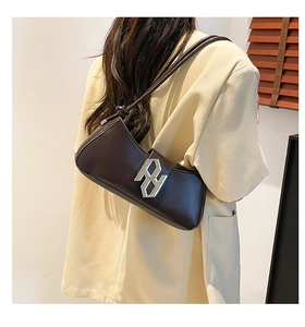 Detail view of a dark brown underarm bag with silver geometric buckle and leather strap