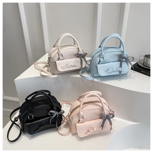 Detail of four colorful bow handbags with ribbons in white, blue, black and pink