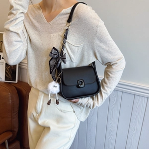 Sac bandoulière noir chic avec bandoulière à nœud rayé et pendentif en peluche doux