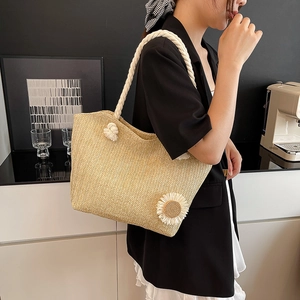 Straw bucket bag with thick rope handle and sunflower detail shown on a model