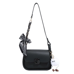Minimalist black square crossbody bag with a striped bow and plush pendant on white background