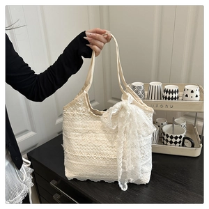 Detail of the layered lace texture and large bow on this white summer beach tote bag