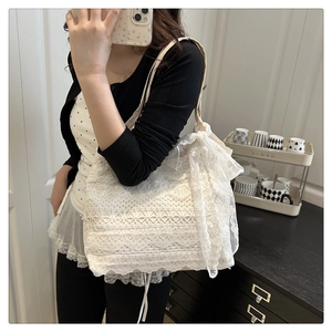 Detailed view of white lace tote bag with floral embroidery and bow knot handle