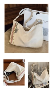 Detail shot of a large white hobo bag with woven rope accents on a wooden shelf