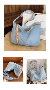 Detail of light blue faux suede tote bag featuring bohemian braided tassel and metal charms