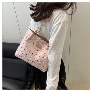 Détail du sac cabas rose brodé de nœuds, texture seersucker et bandoulière chaîne