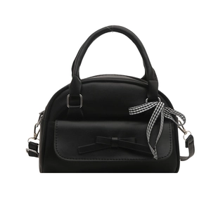 Solid black shell shoulder bag with decorative bow and plaid ribbon on white background