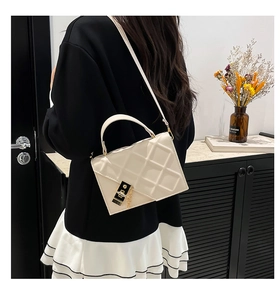 Detailed back view of a beige quilted crossbody bag with a metal chain and turn-lock