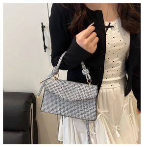 Détail du sac bandoulière avec motif géométrique noir et blanc et poignée à nœud