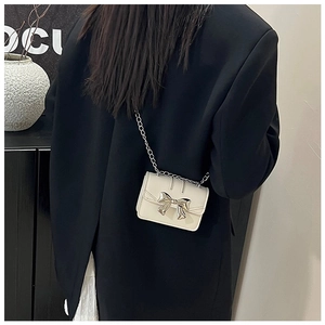 Back view of a mini off-white crossbody bag with metallic bow and silver chain strap