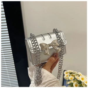 Silver mini crossbody bag featuring a metallic bow detail and chunky chain strap