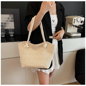 Minimalist straw tote bag with braided herringbone texture and white rope knot handles