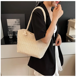 Detail of beige woven tote bag with herringbone pattern and white cotton rope handles