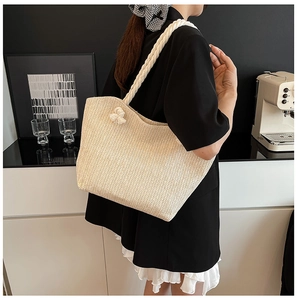 Detail of beige woven tote bag showing chevron pattern texture and soft cotton rope handle