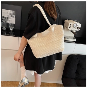 Detail of hand-woven straw tote texture and thick white cotton rope handles