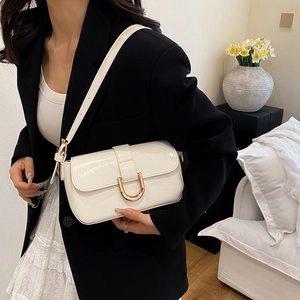 Glossy white faux leather shoulder bag with gold horseshoe buckle and adjustable strap