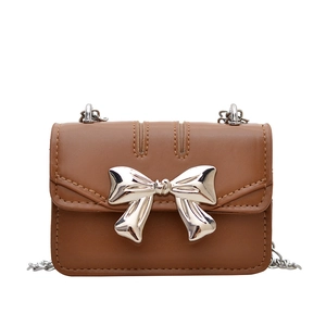 Mini brown leather crossbody bag with silver bow accent and delicate chain strap