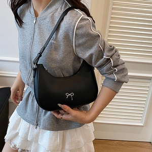 Chic black crescent underarm bag with a silver bow ornament and adjustable strap