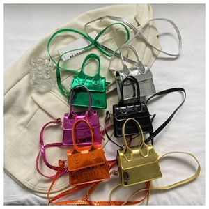 Detail shot of mini crocodile pattern handbags in six vibrant metallic colors