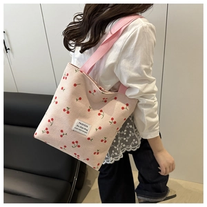 Pink corduroy tote bag with cherry print detail and stylish fabric logo patch