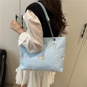 Light blue bubble textured tote bag with butterfly embroidery and silver chain strap