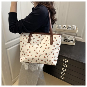 Détail du grand sac cabas avec imprimé cerise rouge et bandoulières en cuir marron