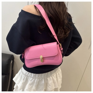 Gros plan du sac baguette en cuir PU rose avec fermoir doré et bandoulière large