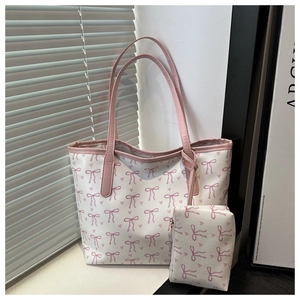 Macro view of white canvas tote with pink bow and heart print and matching pouch