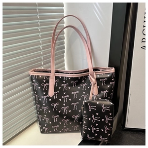 Detail of tote bag with pink bow pattern and matching small pouch in natural light