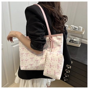 Side view of floral tote bag with pink bow pattern and matching small zipper pouch