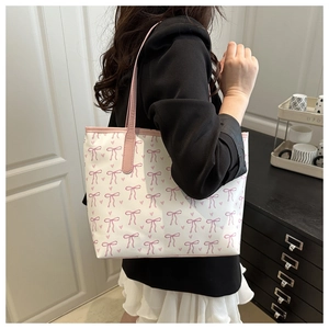 Détail du sac cabas blanc avec imprimés nœuds roses et fines anses en cuir