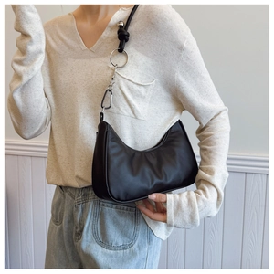 Detail showing black half-moon hobo bag with unique silver ring and knot strap