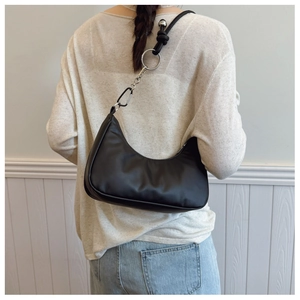 Model wearing a black crescent hobo shoulder bag with silver metal ring strap details