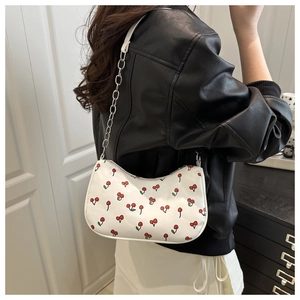 Back view of a white cherry print underarm bag worn with a black leather jacket.