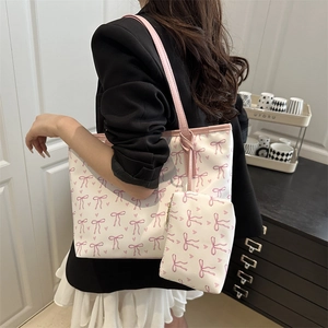 Sweet cream tote bag with pink bow prints and matching pouch shown on a model