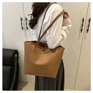 Detail shot of the large capacity tan tote bag showing smooth leather and fine stitching
