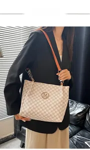 Detail of white tote bag with M-pattern texture and orange leather chain strap