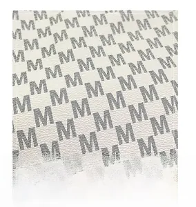 Detailed macro view of beige faux leather material with black M-letter monogram print