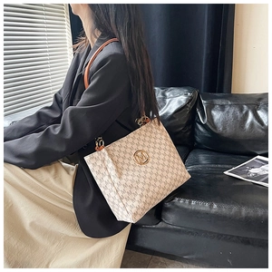 Detail view of cream tote bag with gold M-logo buckle and brown leather chain strap