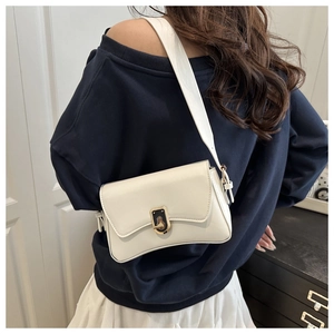 Détail du sac bandoulière en cuir blanc avec fermoir rotatif noir et doré minimaliste
