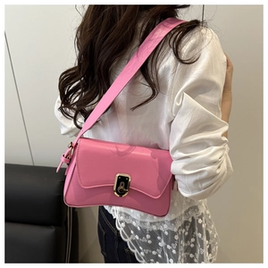 Vue arrière d'un sac bandoulière rose minimaliste avec boucle dorée sur un mannequin