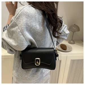 Side view of a black matte leather baguette bag with a golden twist lock on a model