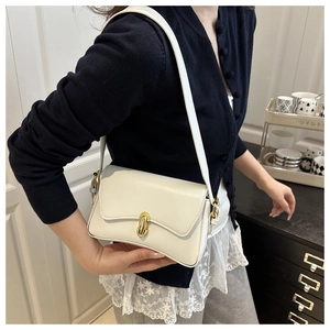 Detail of white leather shoulder bag with oval gold buckle shown on a model