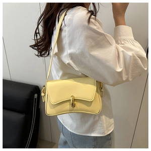 Detail of cream PU leather crossbody bag with gold metallic buckle and curved bottom