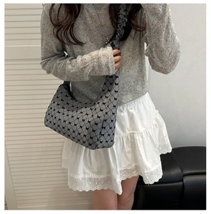 Detail of ruffled strap on black and white gingham shoulder bag with tiny bow patterns