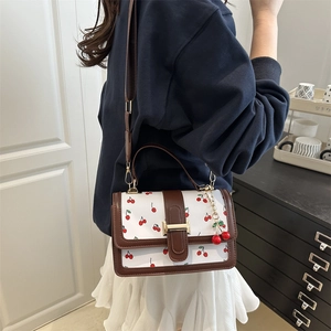 Fashionable white crossbody bag with cherry prints and brown leather handles for women