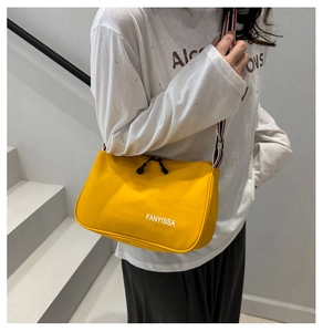 Detail of yellow nylon crossbody bag with striped wide strap and brand logo print